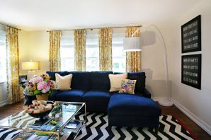 Интерьер гостиной с синим угловым диваном