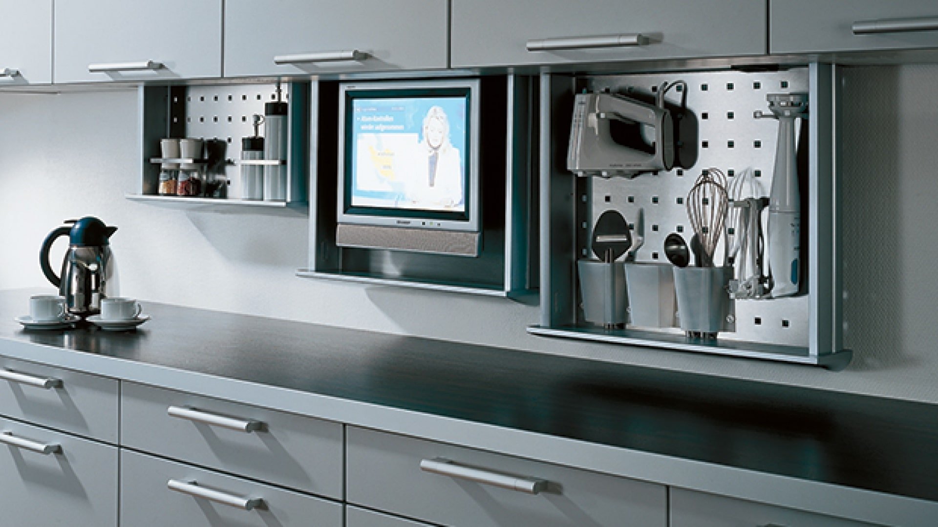 Встроенные телевизоры для кухни. Телевизор встроенный в кухонный шкаф. Выдвижной телевизор на кухне. Кухонный шкаф с телевизором. Встраиваемый телевизор для кухни.