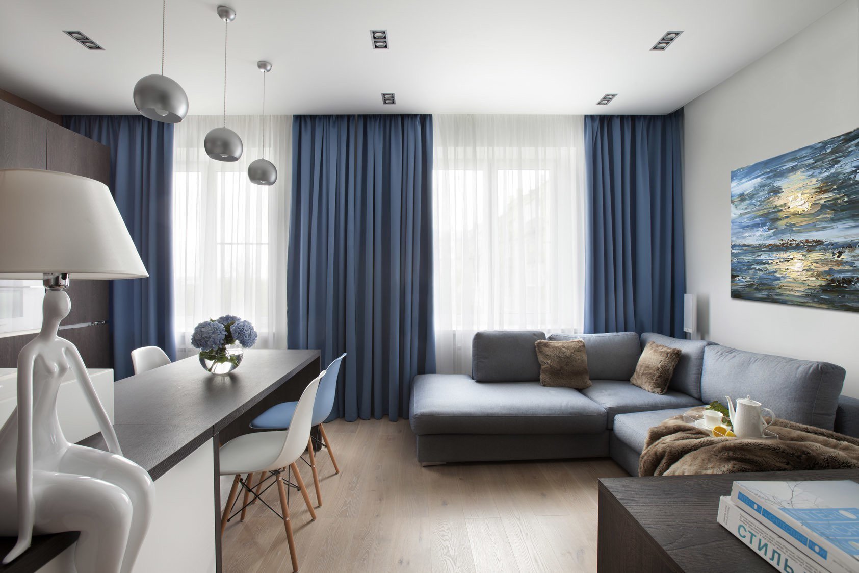 Интерьер комнаты с синим диваном и синими шторами
