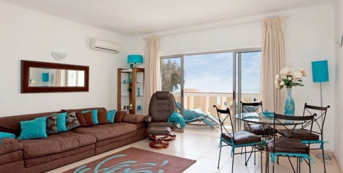 Коричневый диван и бирюзовые шторы